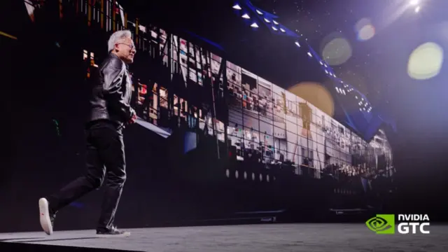 ג'נסן הואנג, מייסד ומנכ"ל NVIDIA, צועד על במה כהה בכנס GTC בברלין, עם מסך ענק מאחוריו