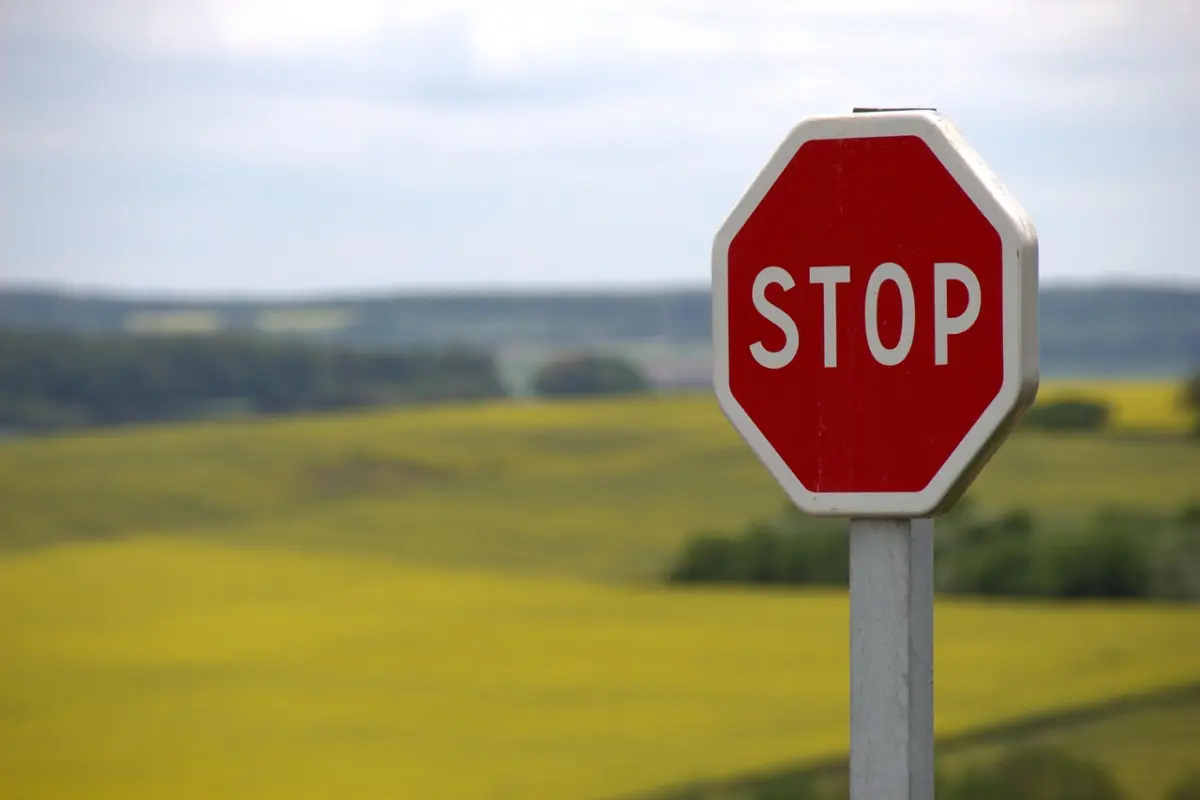 תמרור "STOP" אדום על רקע שדה צהוב ופתוח, כסמל לעצירה ולסירוב