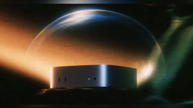 Mac mini מכסף מואר תחת כיפה זוהרת של אור, על רקע כהה