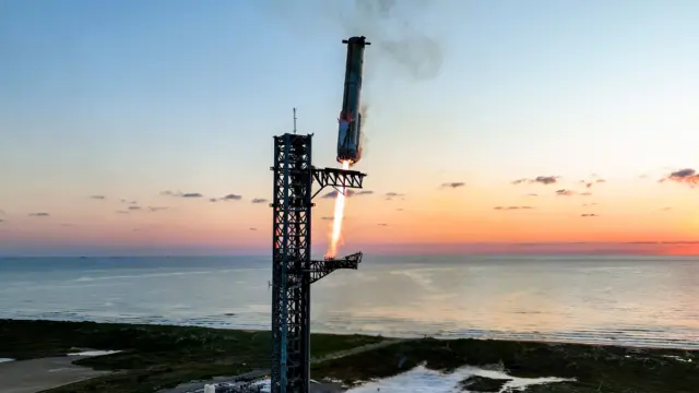 טיל Starship של SpaceX עומד על מגדל השיגור בזריחה, ליד חוף הים